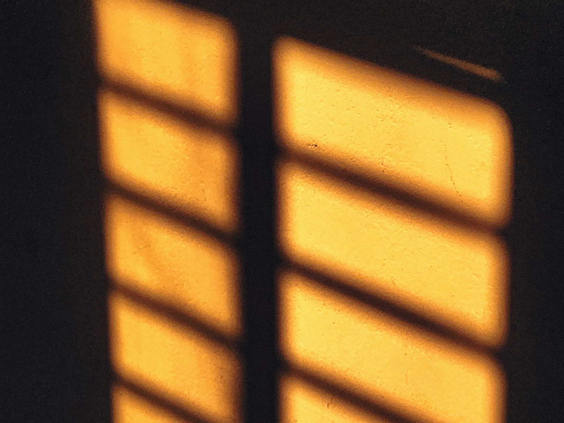 Golden light streaming through what appears to be window blinds