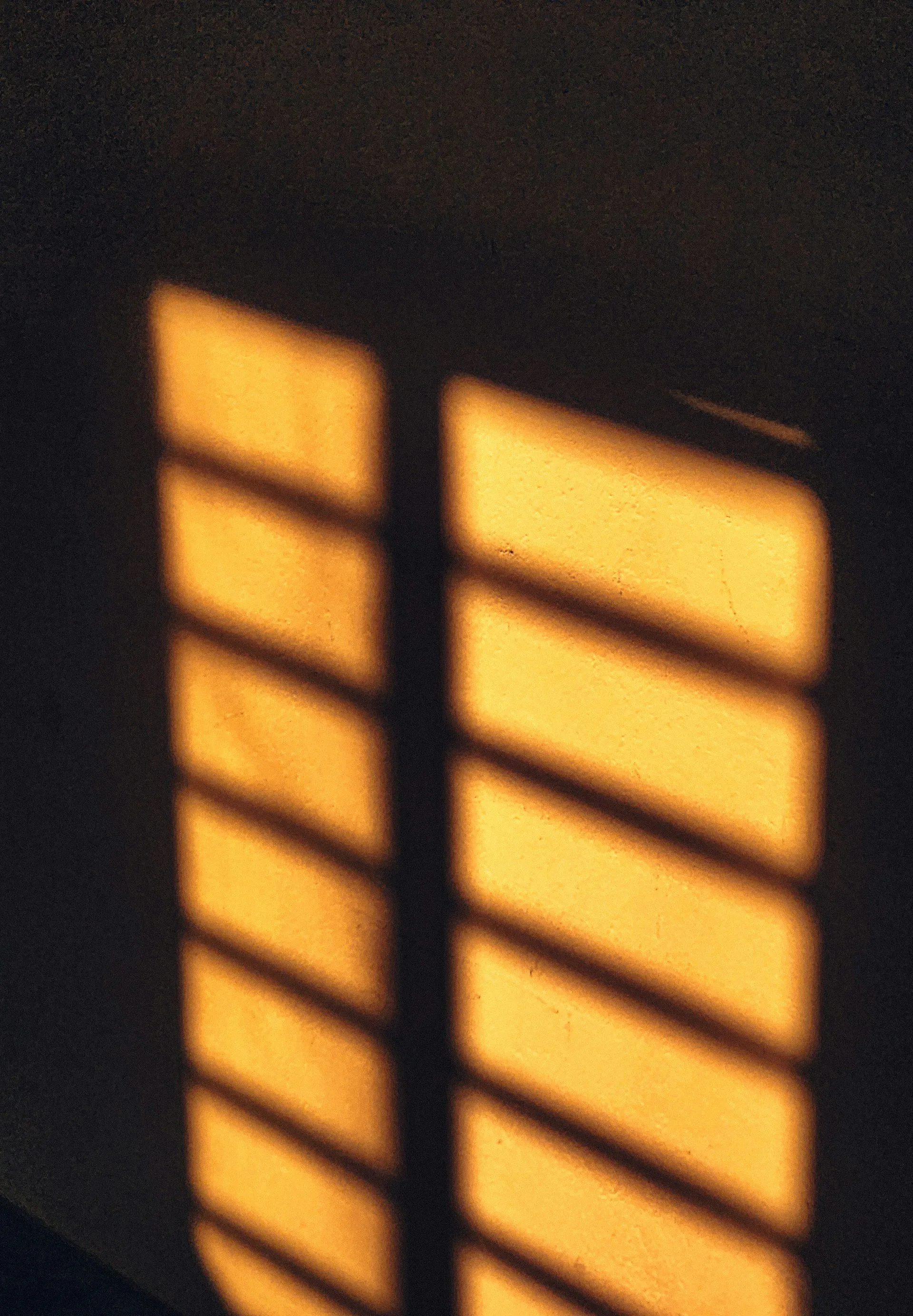 Golden light streaming through what appears to be window blinds